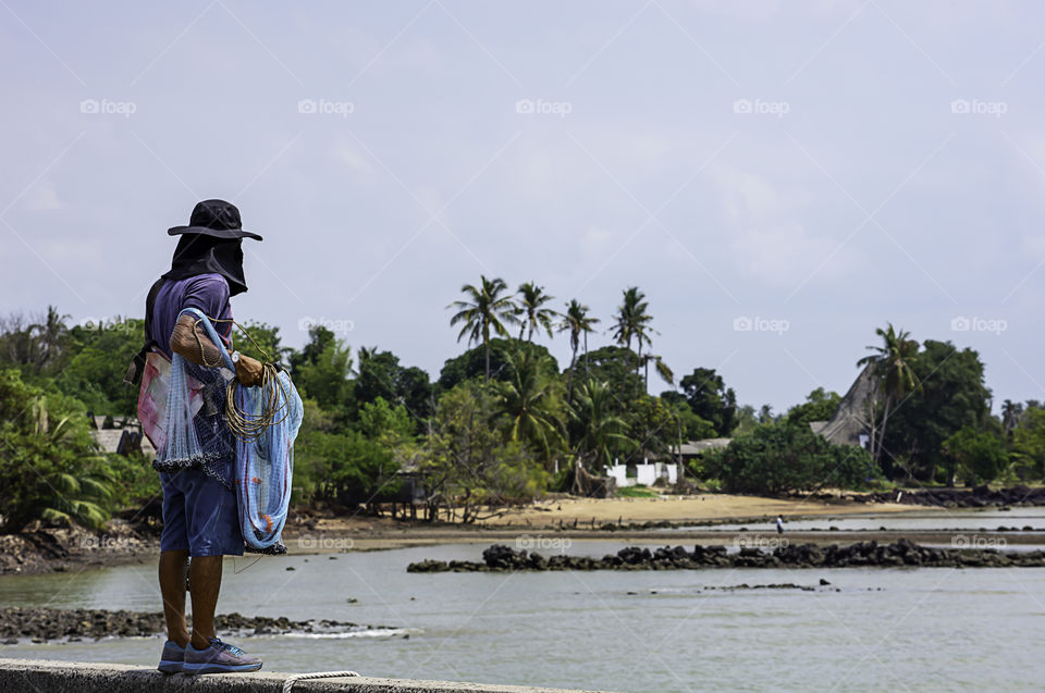 Man holding fishing nets  Background sea and sky.