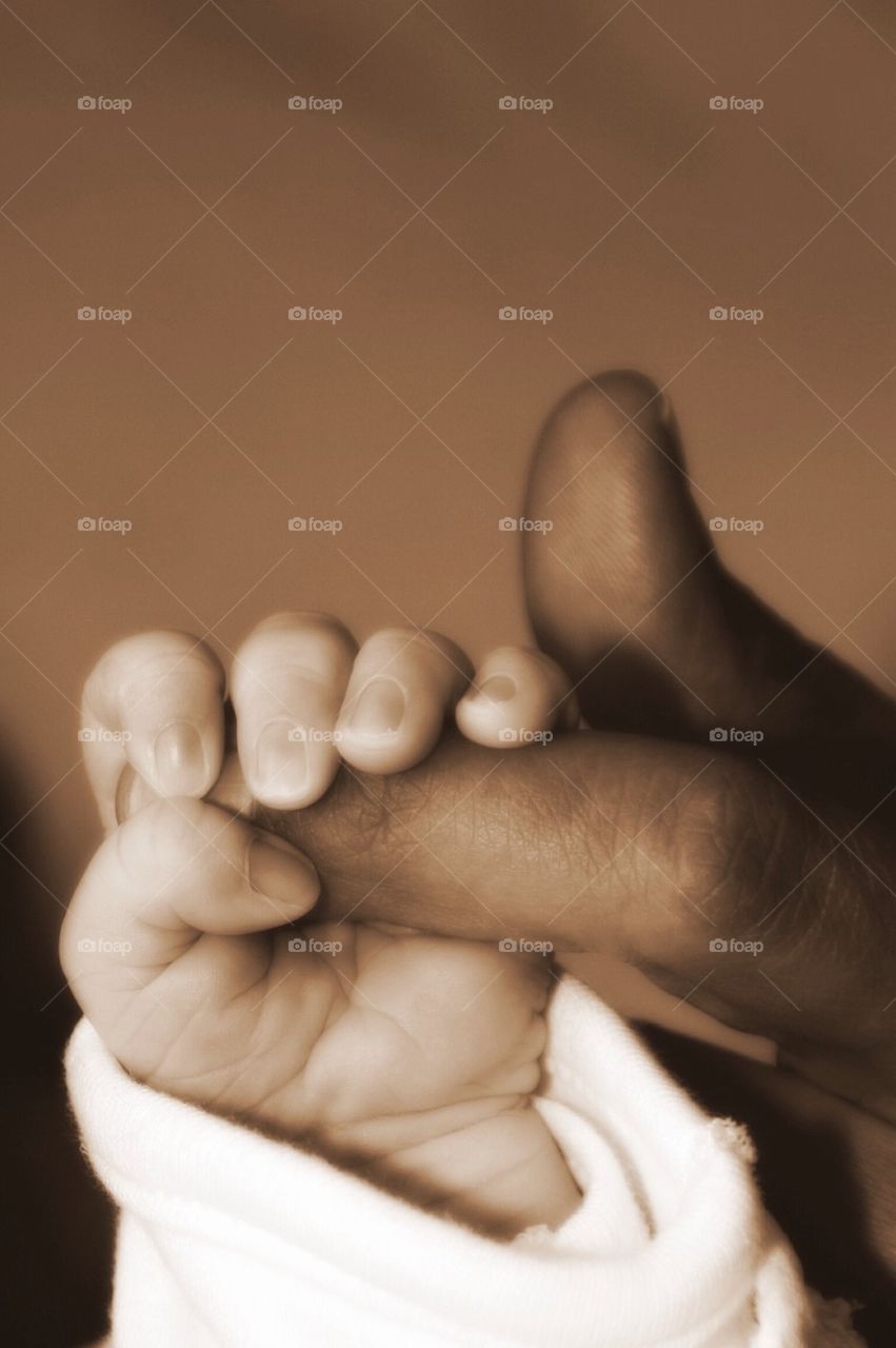 Baby Girl is holding moms finger