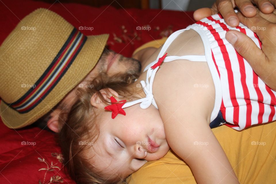 Father holding daughter while she sleeps