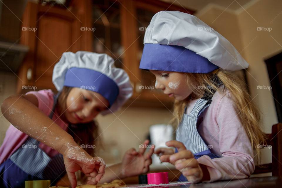 Little sisters cooking the biscuits 