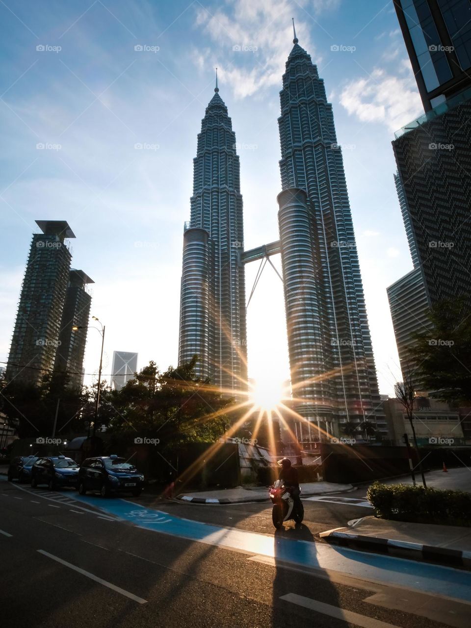The morning sunrise coming through the base of the Petronas twin towers in Kuala Lumpur, Malaysia