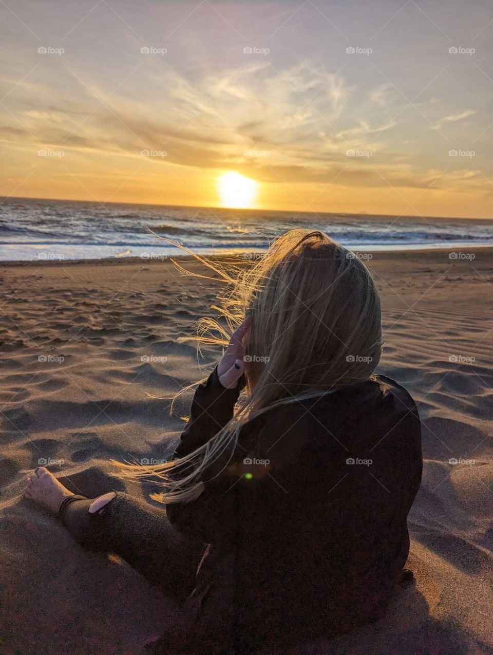 sitting on the windy beach at sunset oceanside ocean beach vacation girl on the beach at sunset