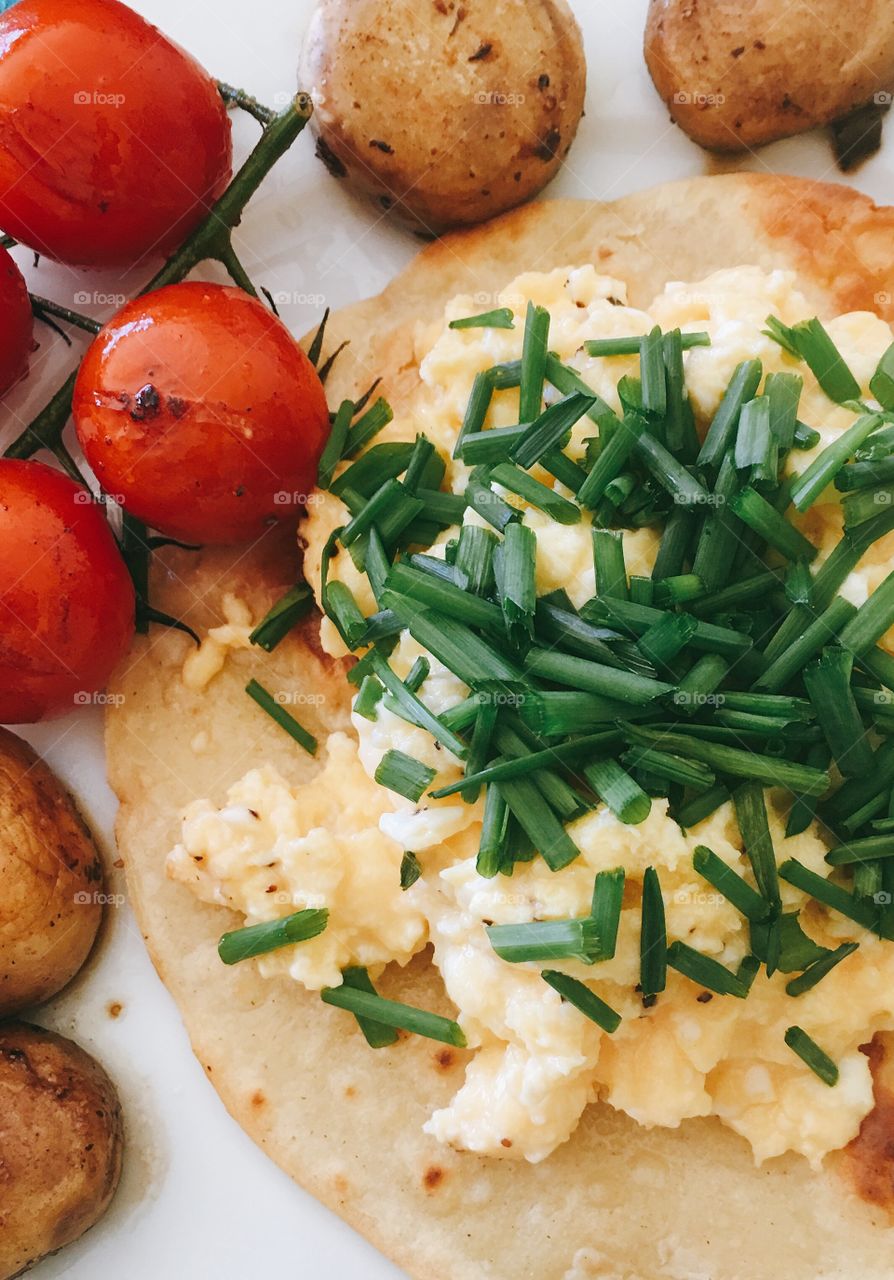 Breakfast of Grilled tomatoes on the vine, mushroom caps, and scrambled eggs served atop a crispy corn tortilla) using Chef Gordon Ramsey’s recipe for eggs topped with chives.