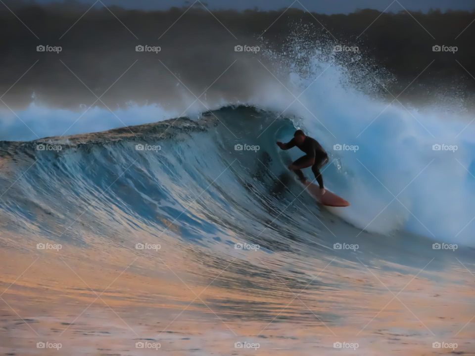 Surfer riding a barrel wave at sunset 🌅