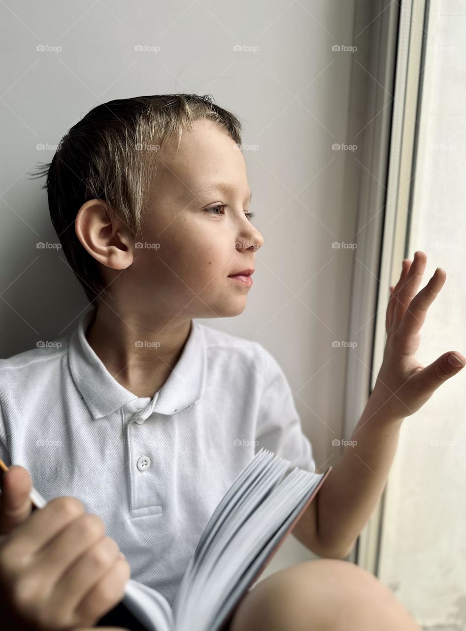 Portrait of a child looking out the window