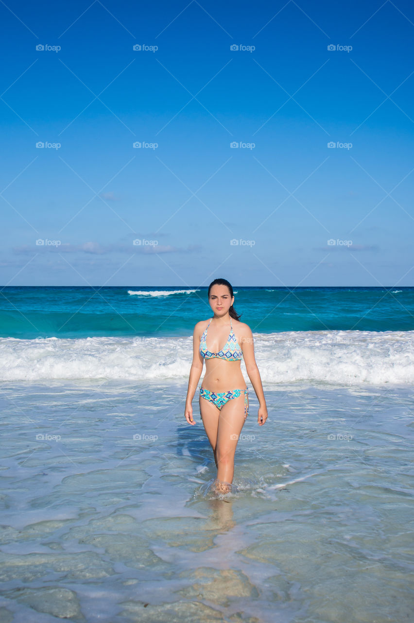 Beautiful girl walking in the ocean