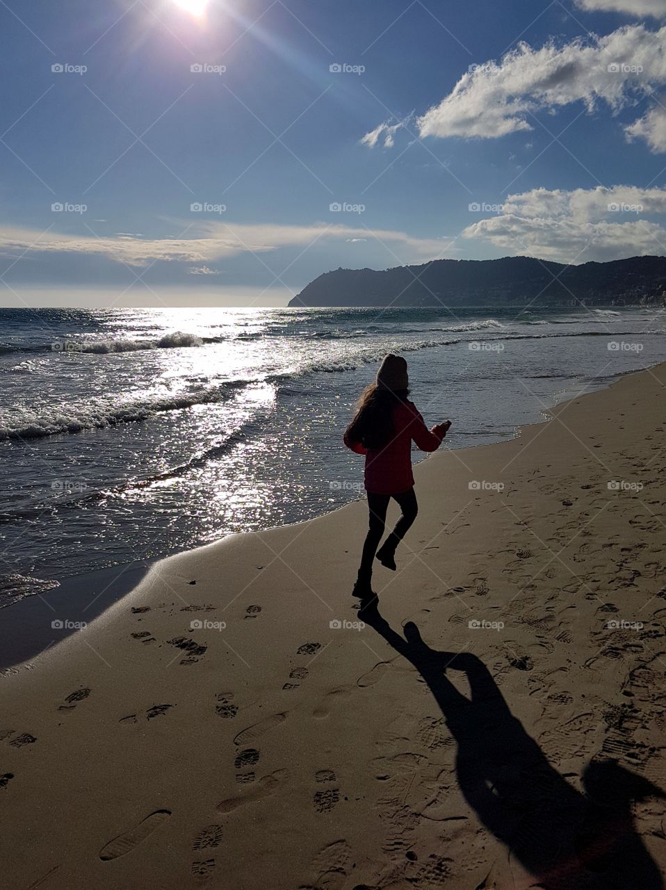 Running girl on the beach in a sunny day  in springtime