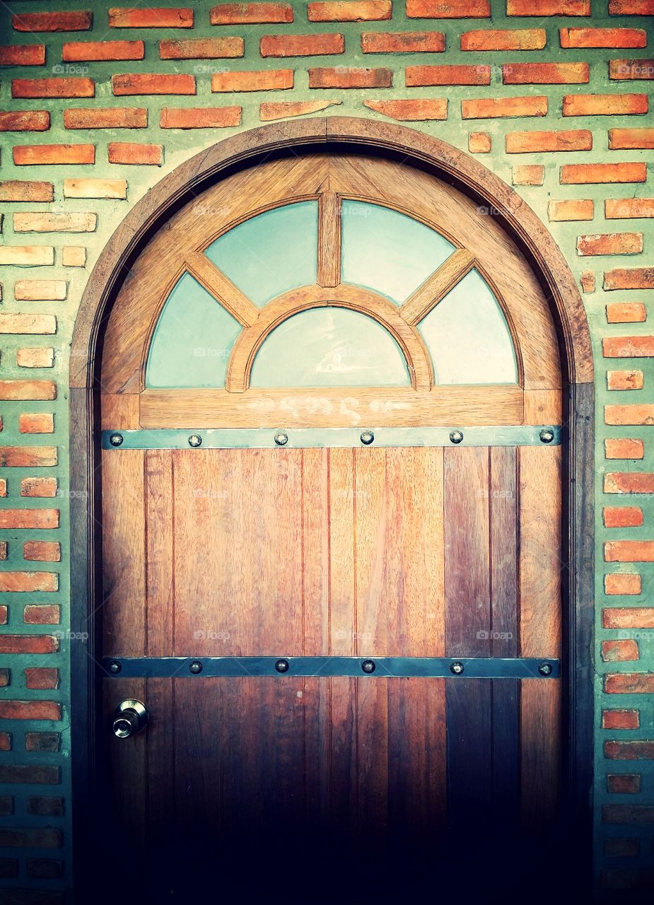 Beautiful wooden door on the brick wall.