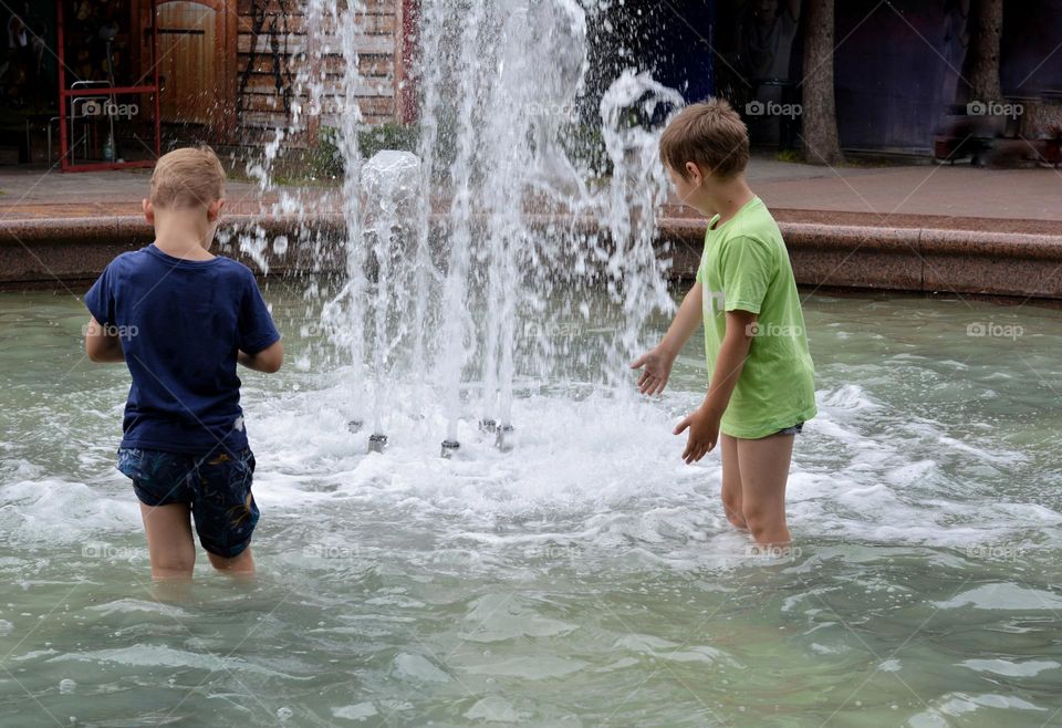 children in water fountain urban nature summer time