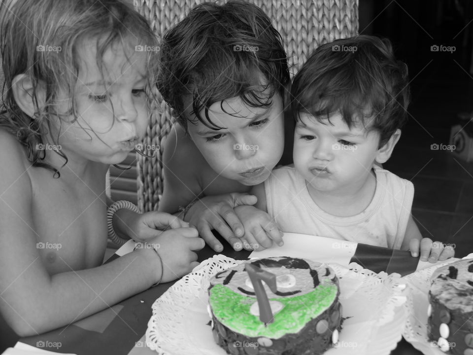 Children's blowing candles on cake