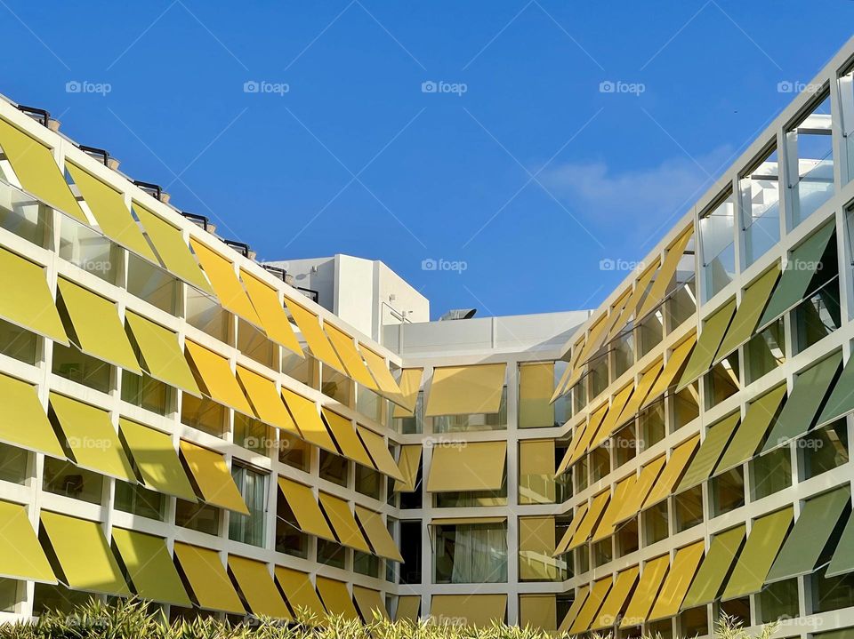 External awnings in all shades of yellow; sun protection; modern and colorful building 