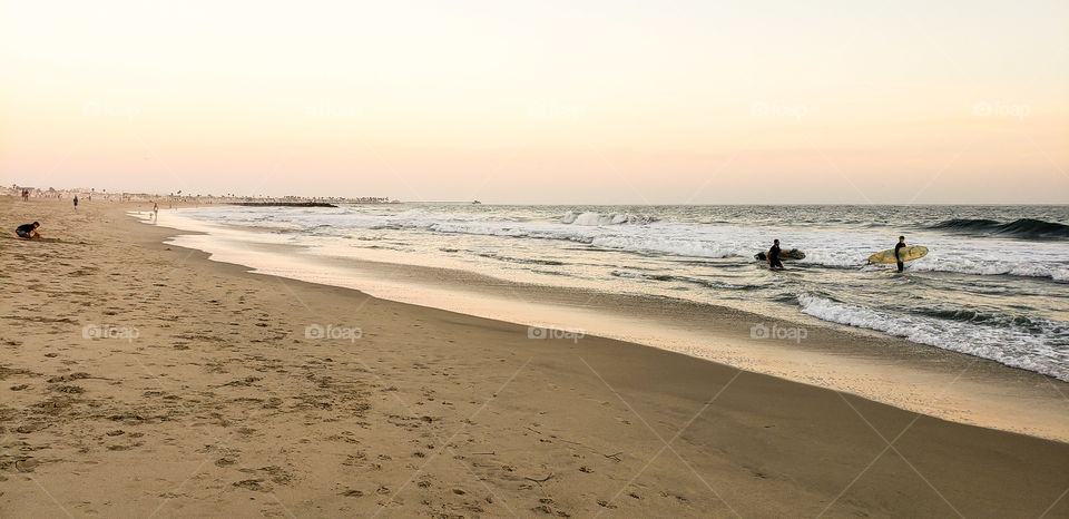 Surfers hitting the water at Newport Beach California