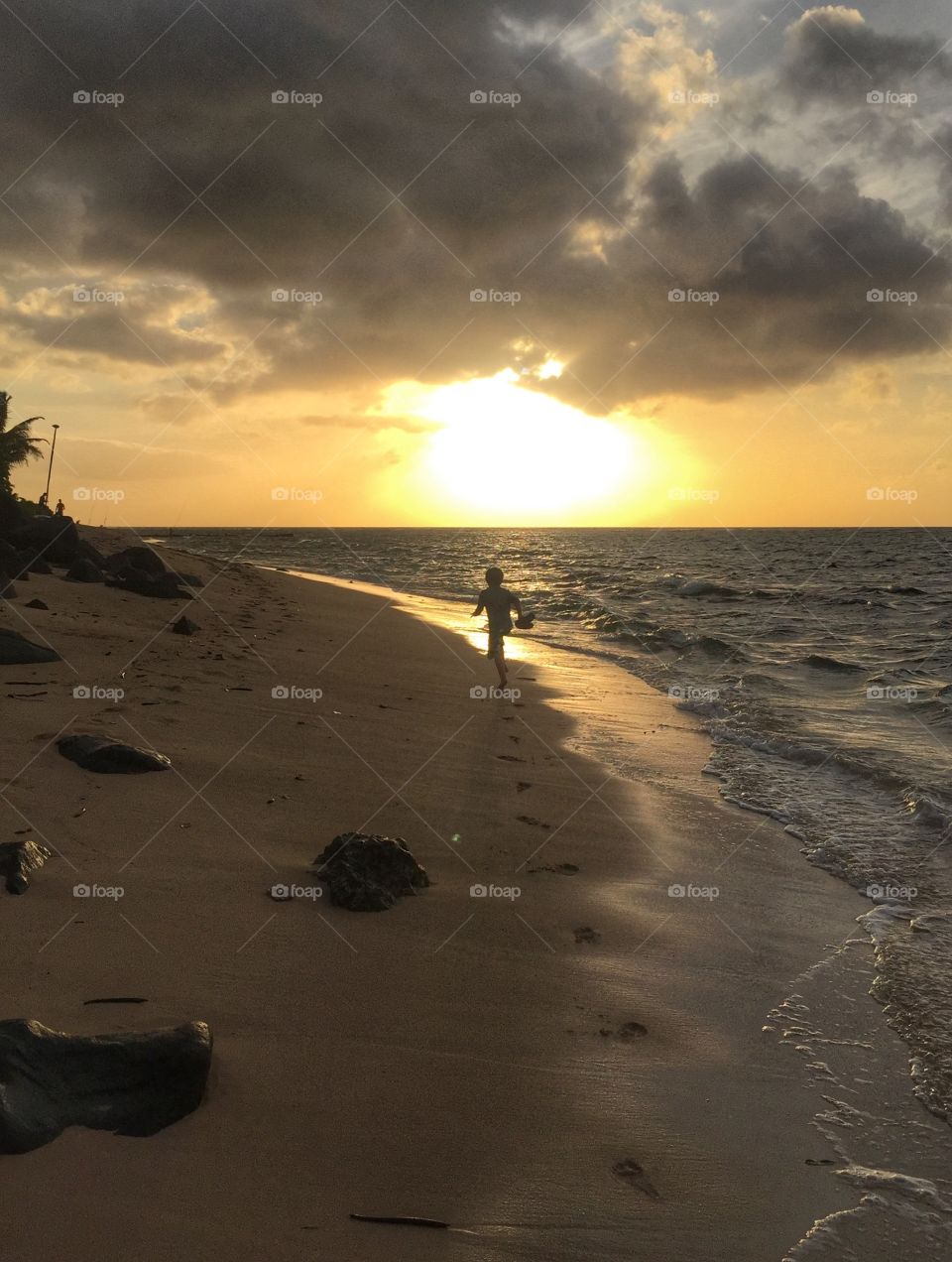 One of my boys running along the beach at sunset in Hawaii