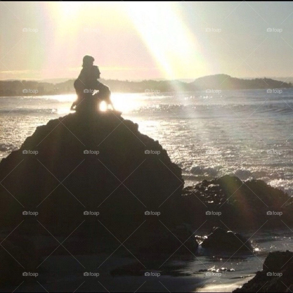 Father and daughter on the beach at sunset.