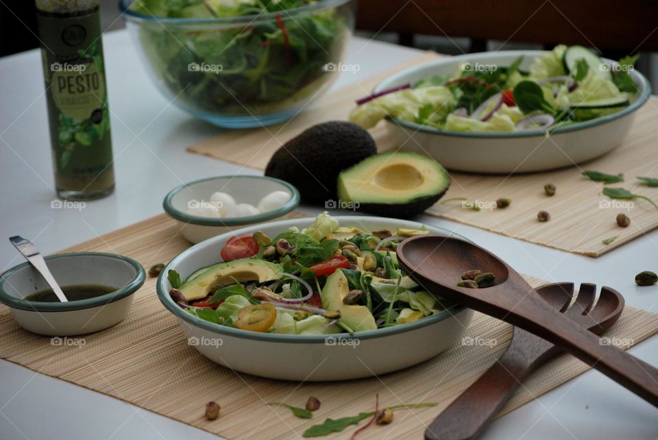 Plate with summer vegetables and dressing - salad avocado tomato mozzarella onion 