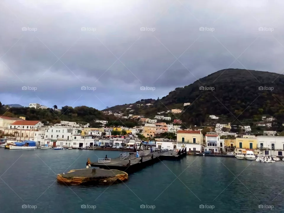 The port of Ischia in a winter morning with cloudy sky and smooth sea