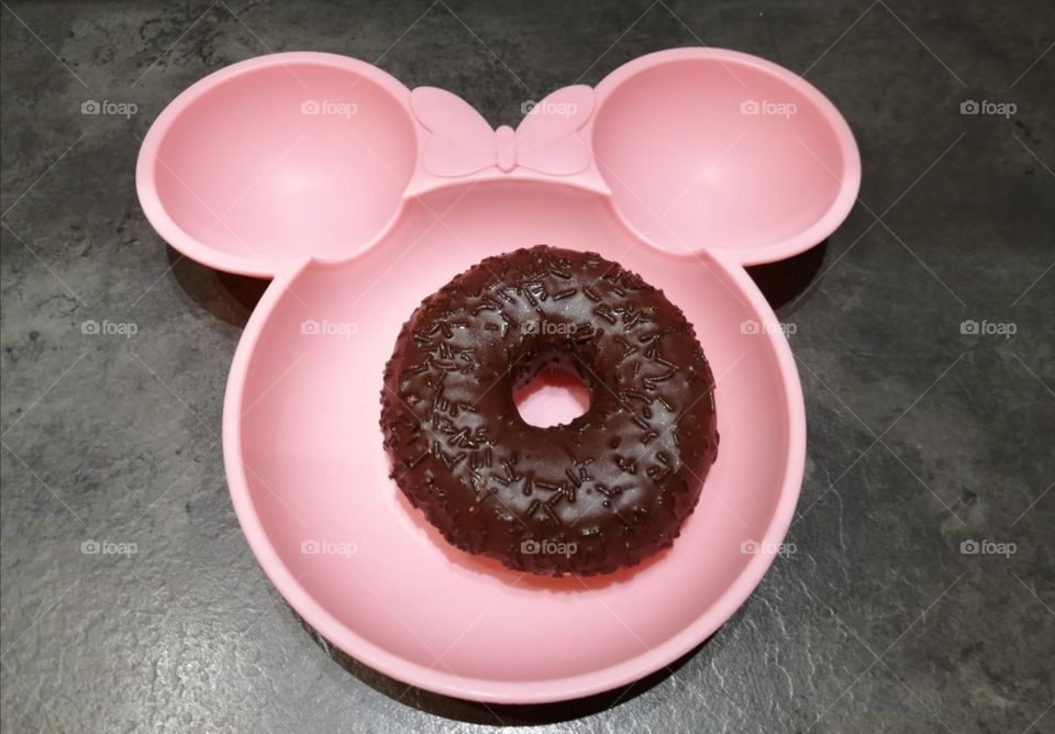 Black donute on pink plate