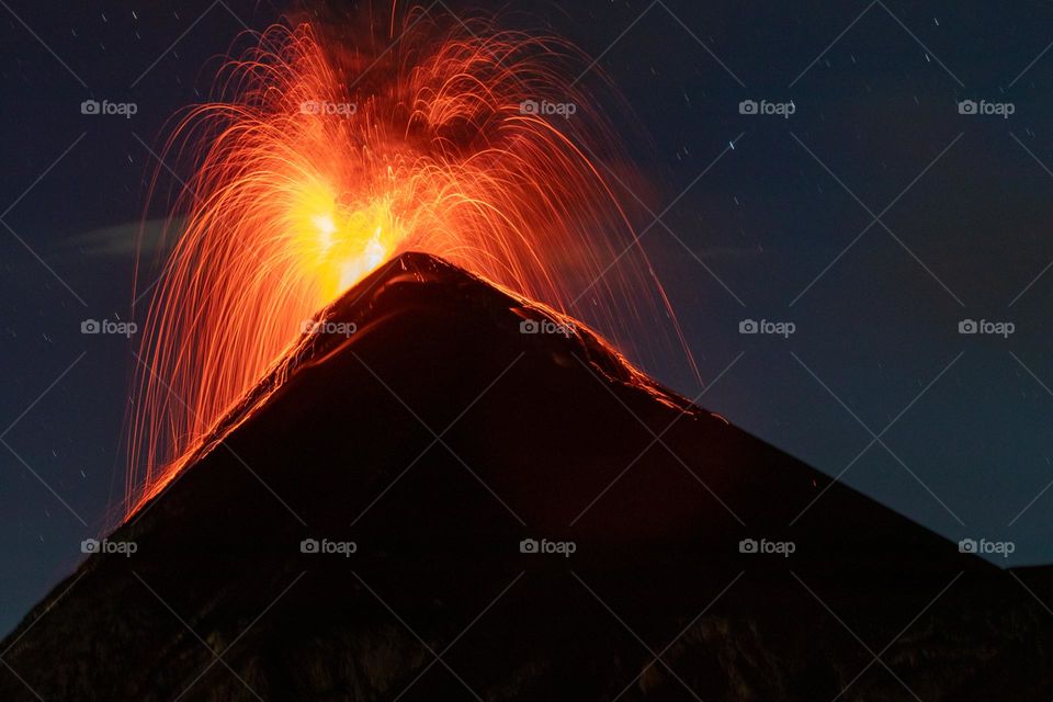 Volcan de fuego erupting in firey explosion at night.