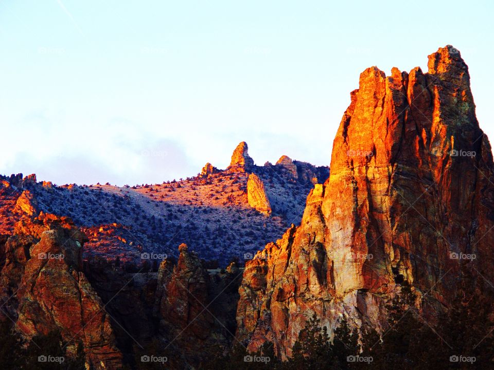 The sun sets over Smith Rocks with snow in the foothills on a winter evening in Central Oregon. 