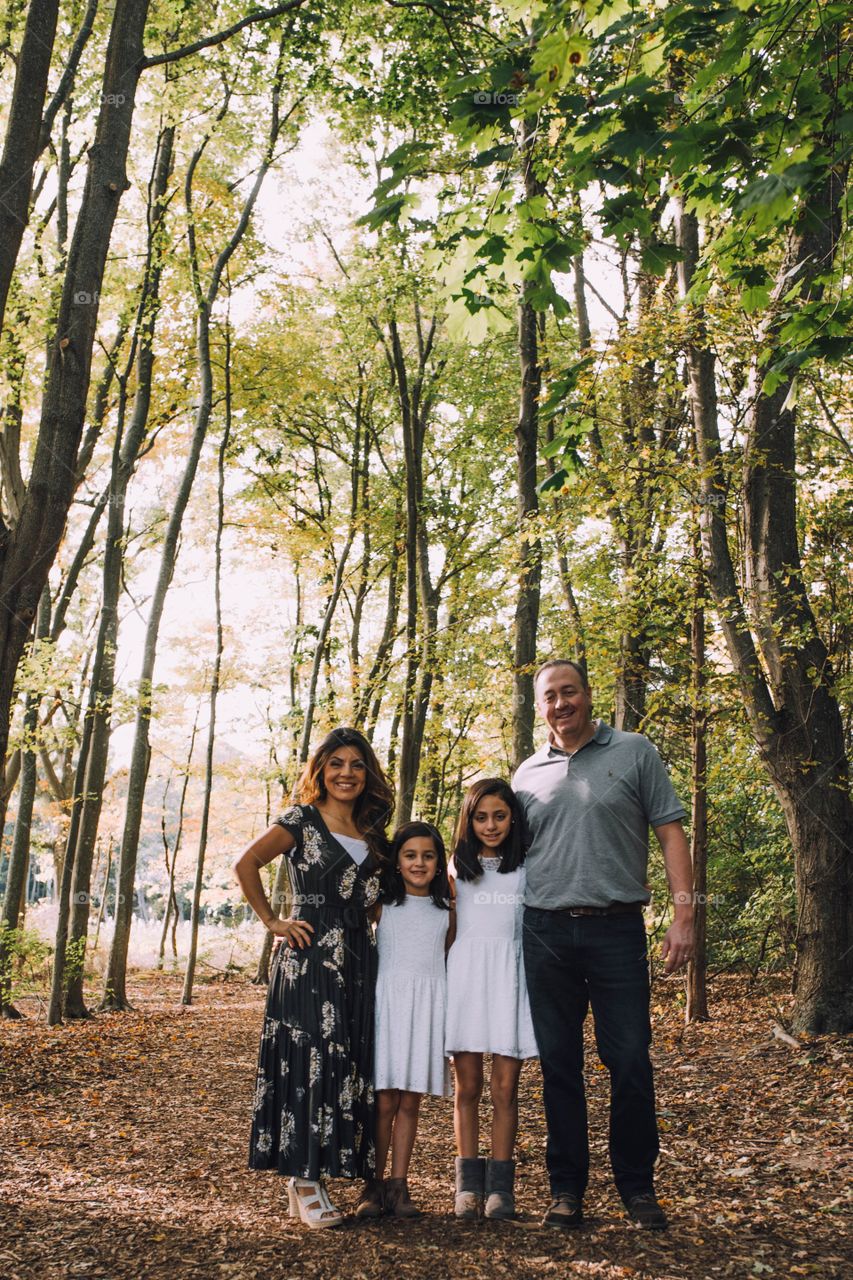 Family of four standing in the beautiful forest