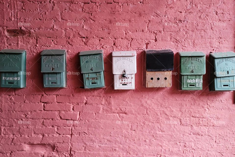 Row of vintage mailboxes on pink wall