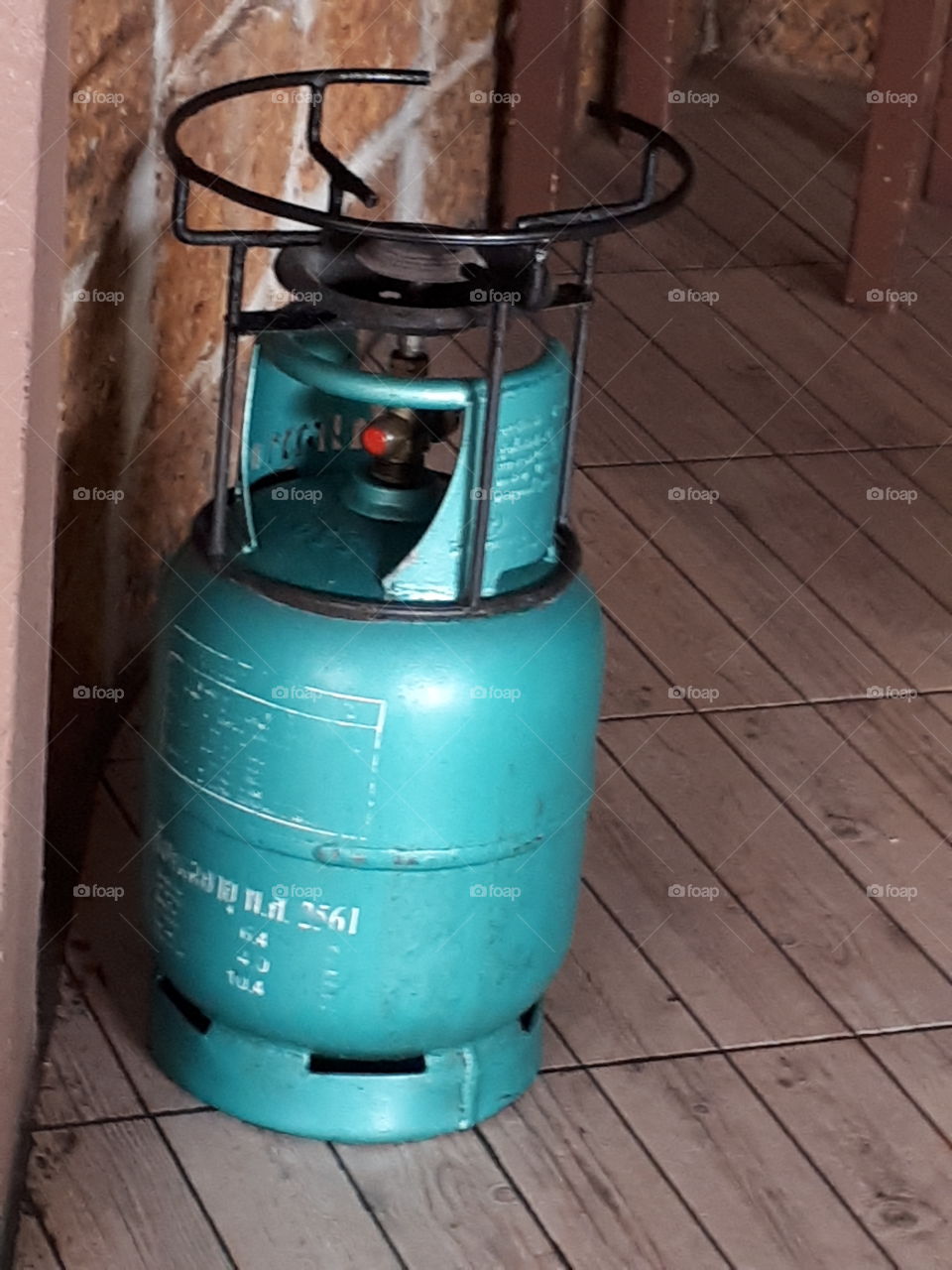 Green gas tank on the wooden floor