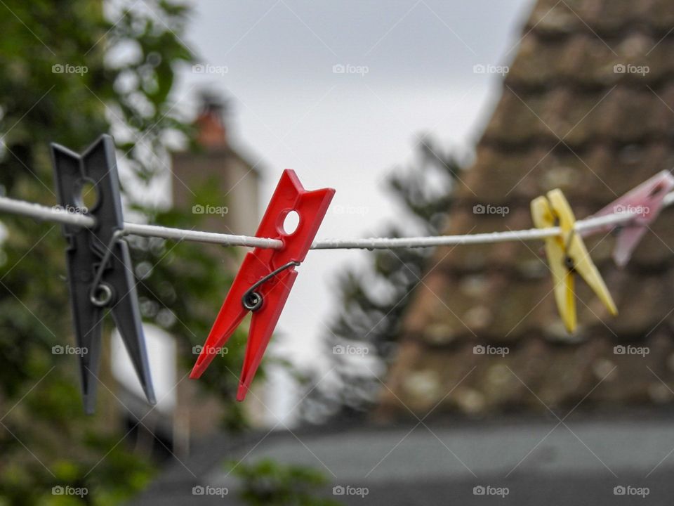 Bright red clothes peg on a washing line.