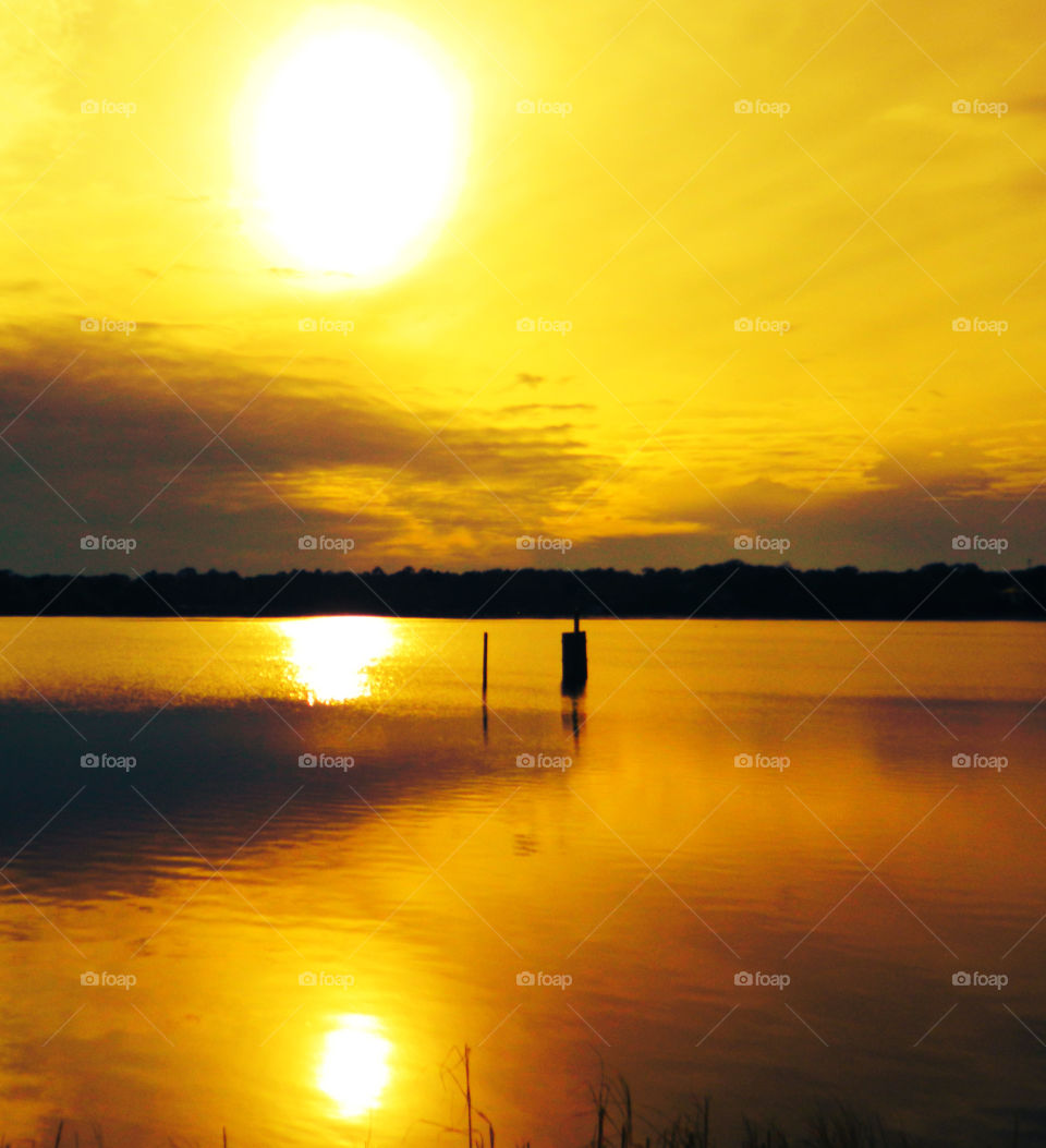 White Hot Sunset. White hot sun descending prior to a magnificent sunset! Notice the double sun reflection in the bay water!