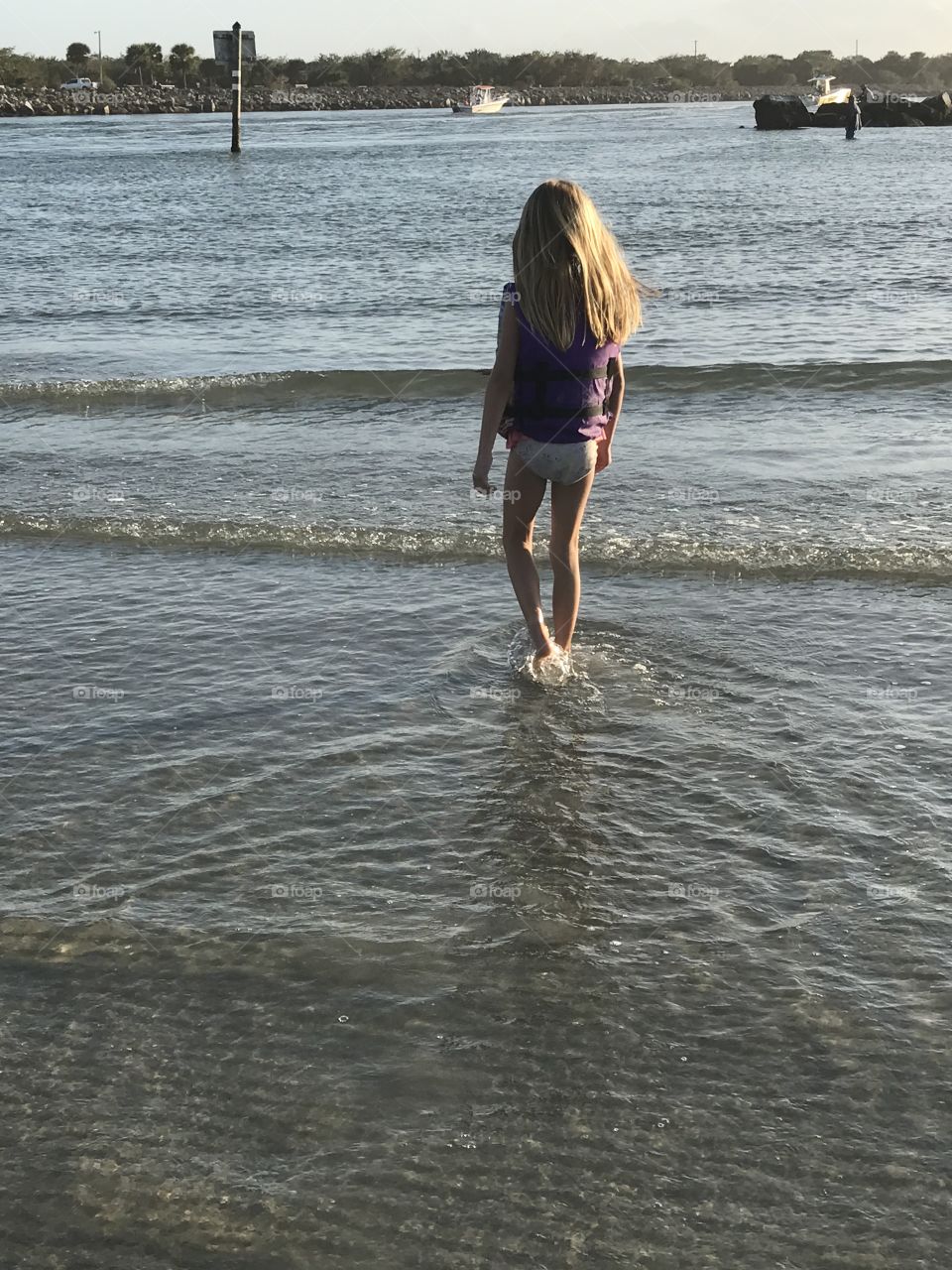 Little girl walking in to the water