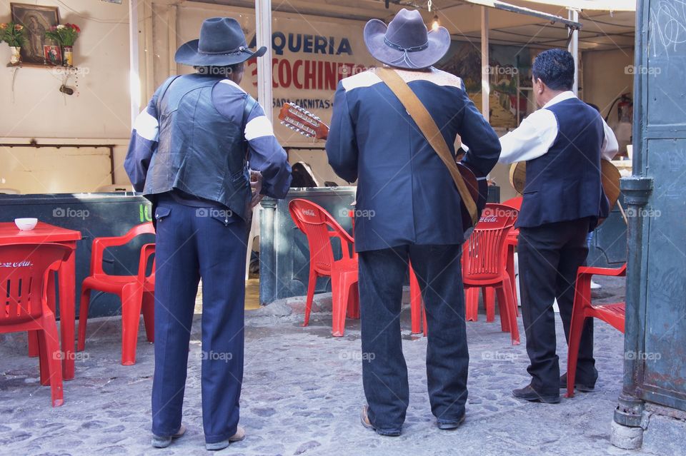 A mariachi band entertains diners at an open air restaurant,