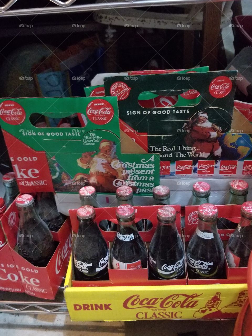 A collection of sealed, vintage coke bottles with Christmas six pack boxes.