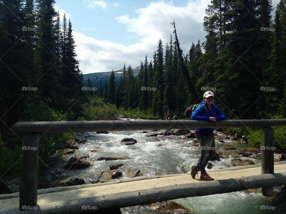 Woman hiking across a bridge