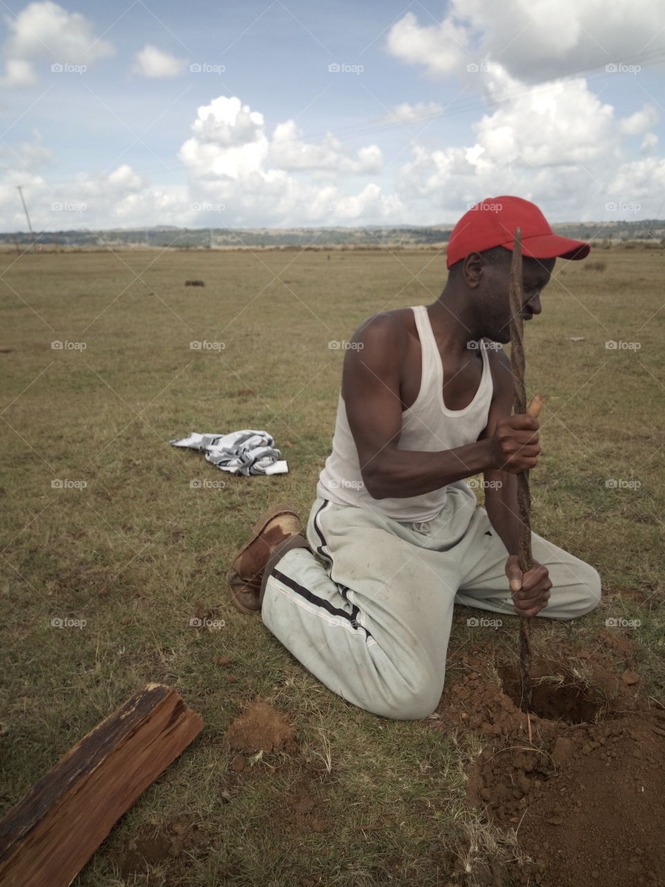 A man digging fencing posts hole in Samburu,Kenya.