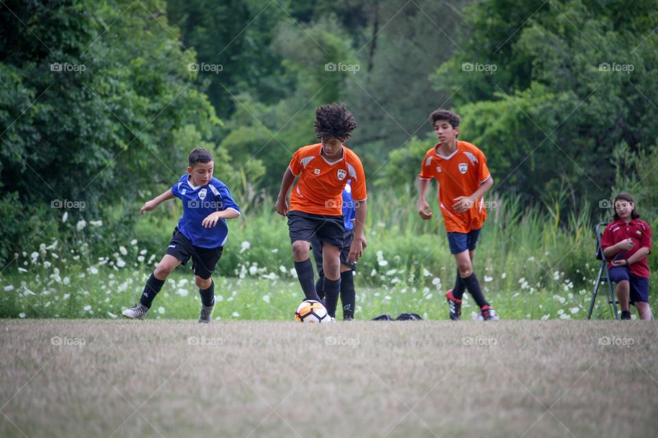 Boys are playing soccer outdoors