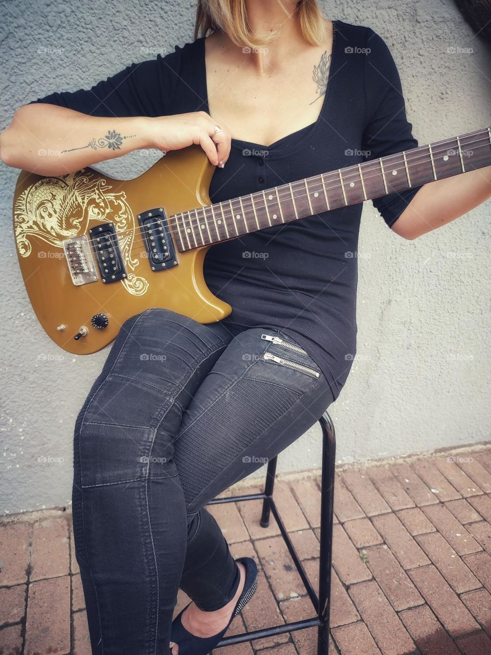 Female sitting with Electric Guitar