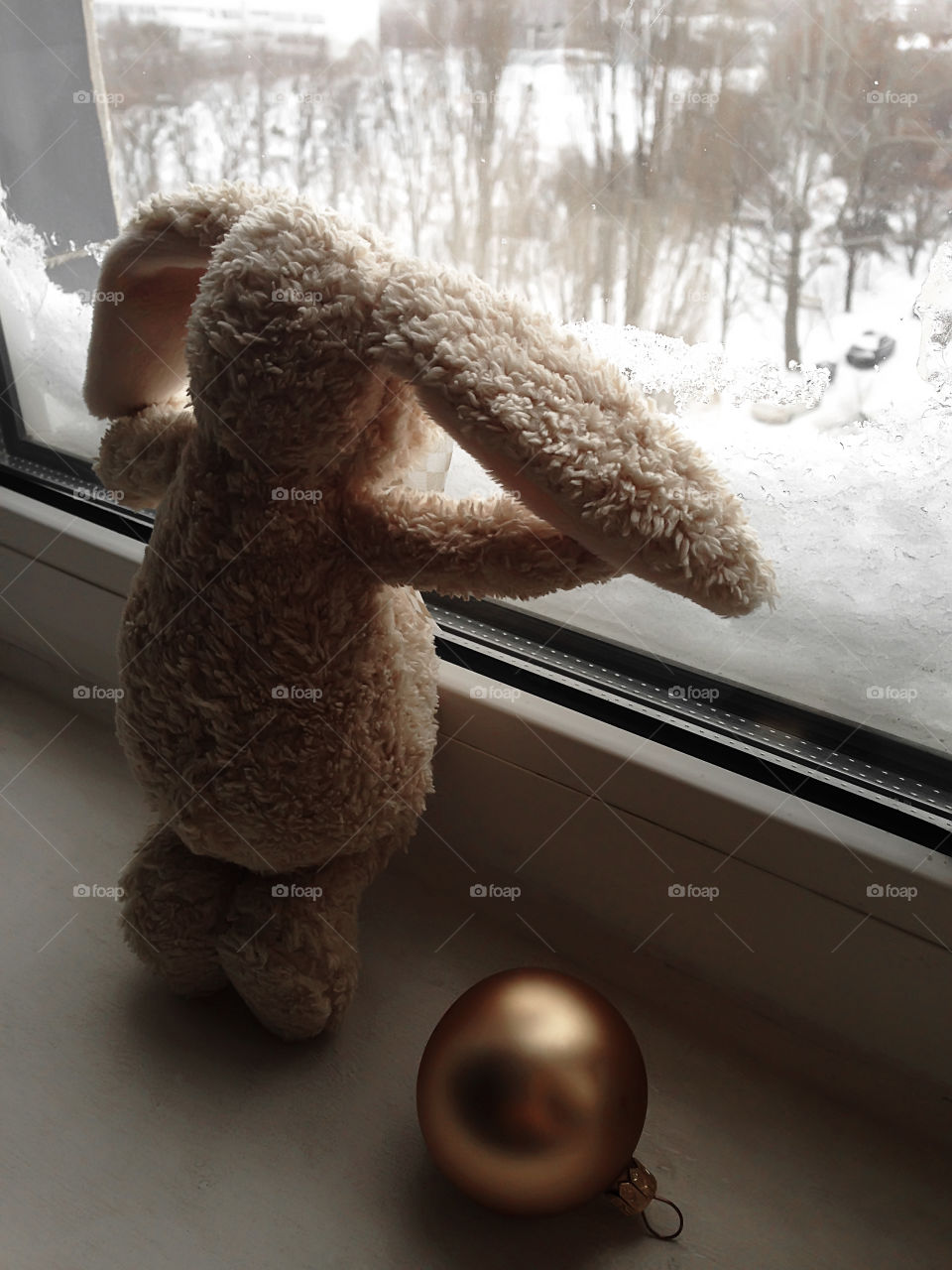 Christmas toy bunny watching the beauty of winter 