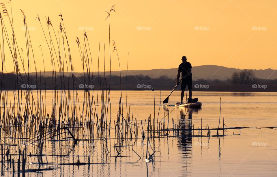 Peddle boarding at sunset