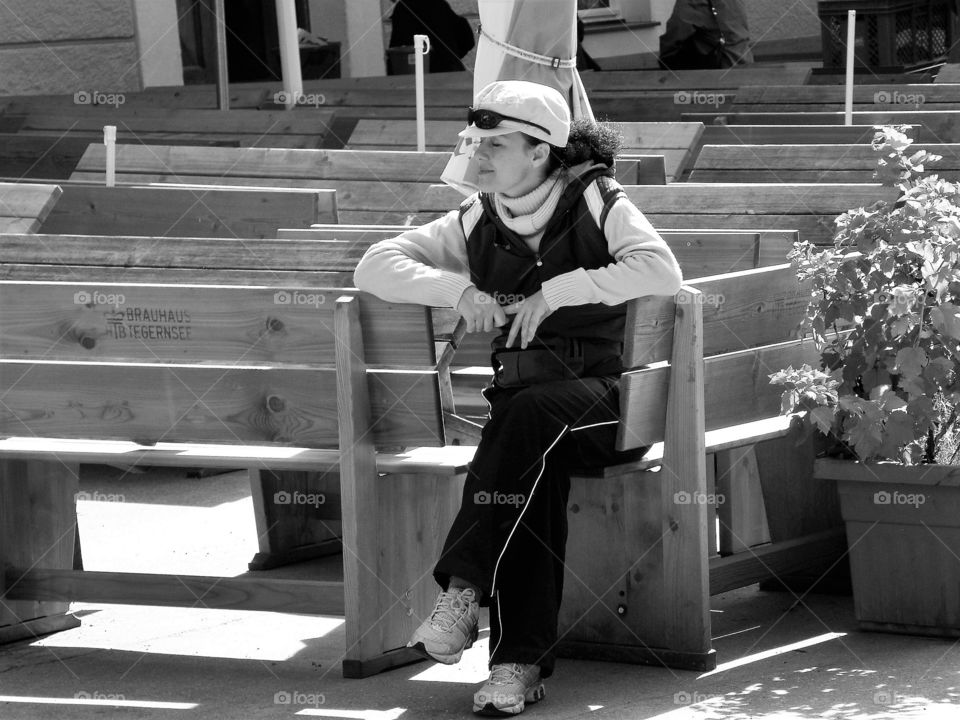 Woman sitting on a wooden bench waiting, Austria