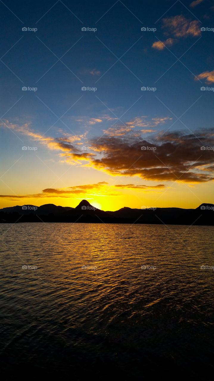 sunset behind mountain range on a lake