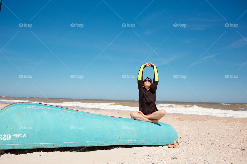 Sportive woman doing yoga at beach 