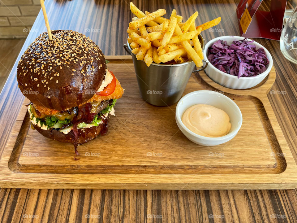 Big burger with fries and coleslaw salat.