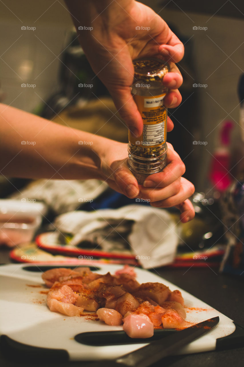 Close-up of a person sprinkling spice on food