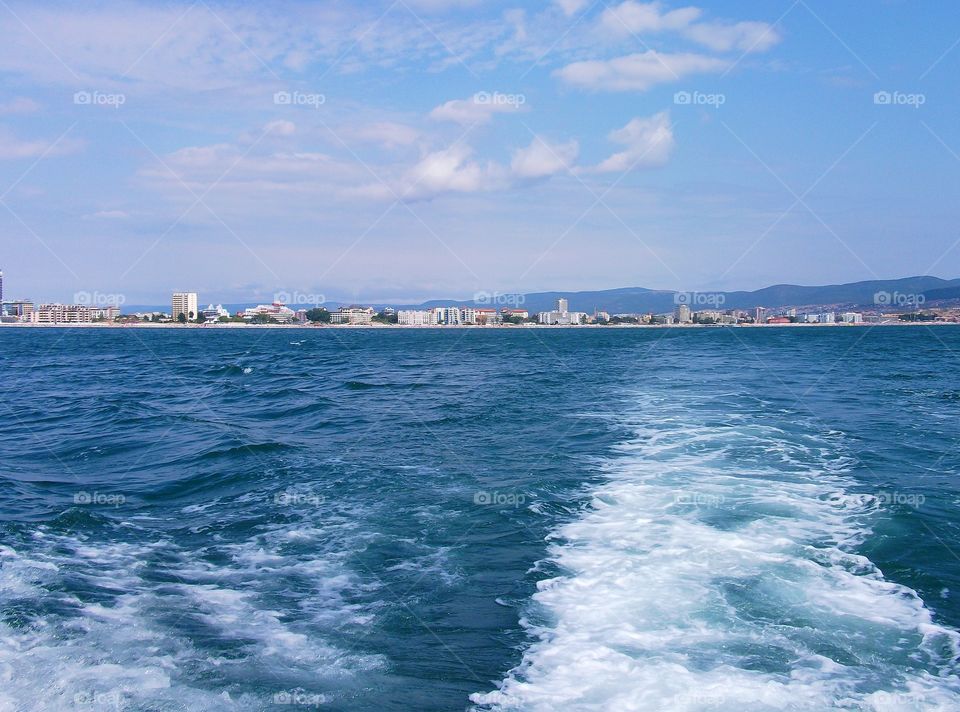 Seascape with horizon line and cityscape. View from yacht