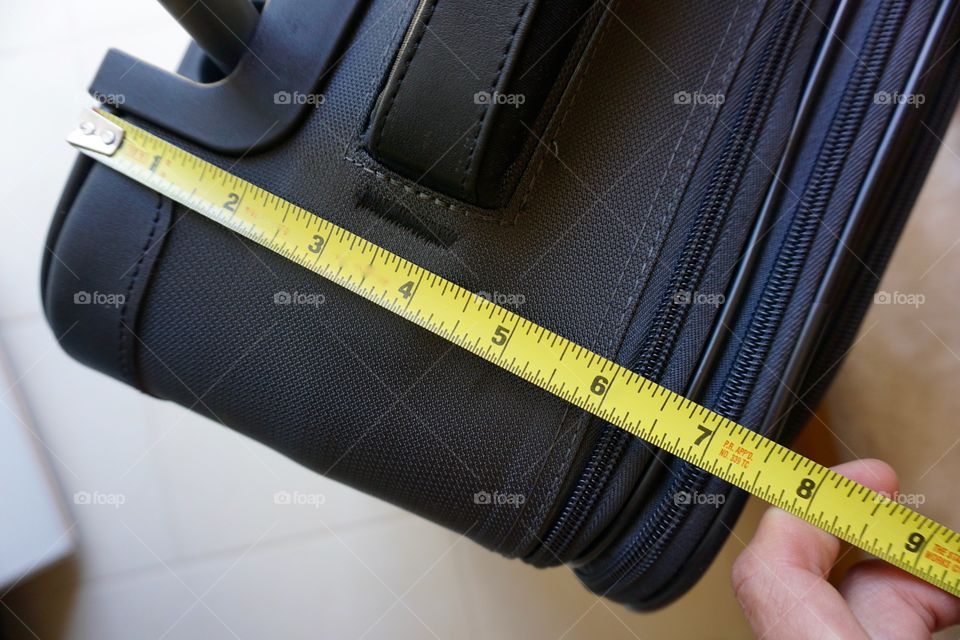Measuring luggage to make sure it meets criteria