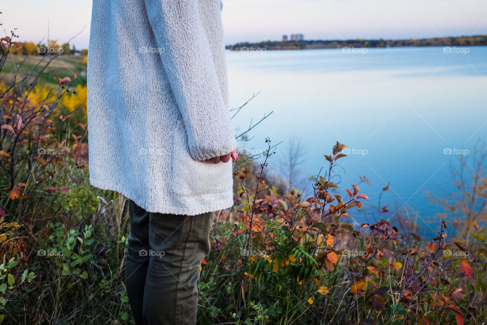 Mid section of a woman standing at lake side