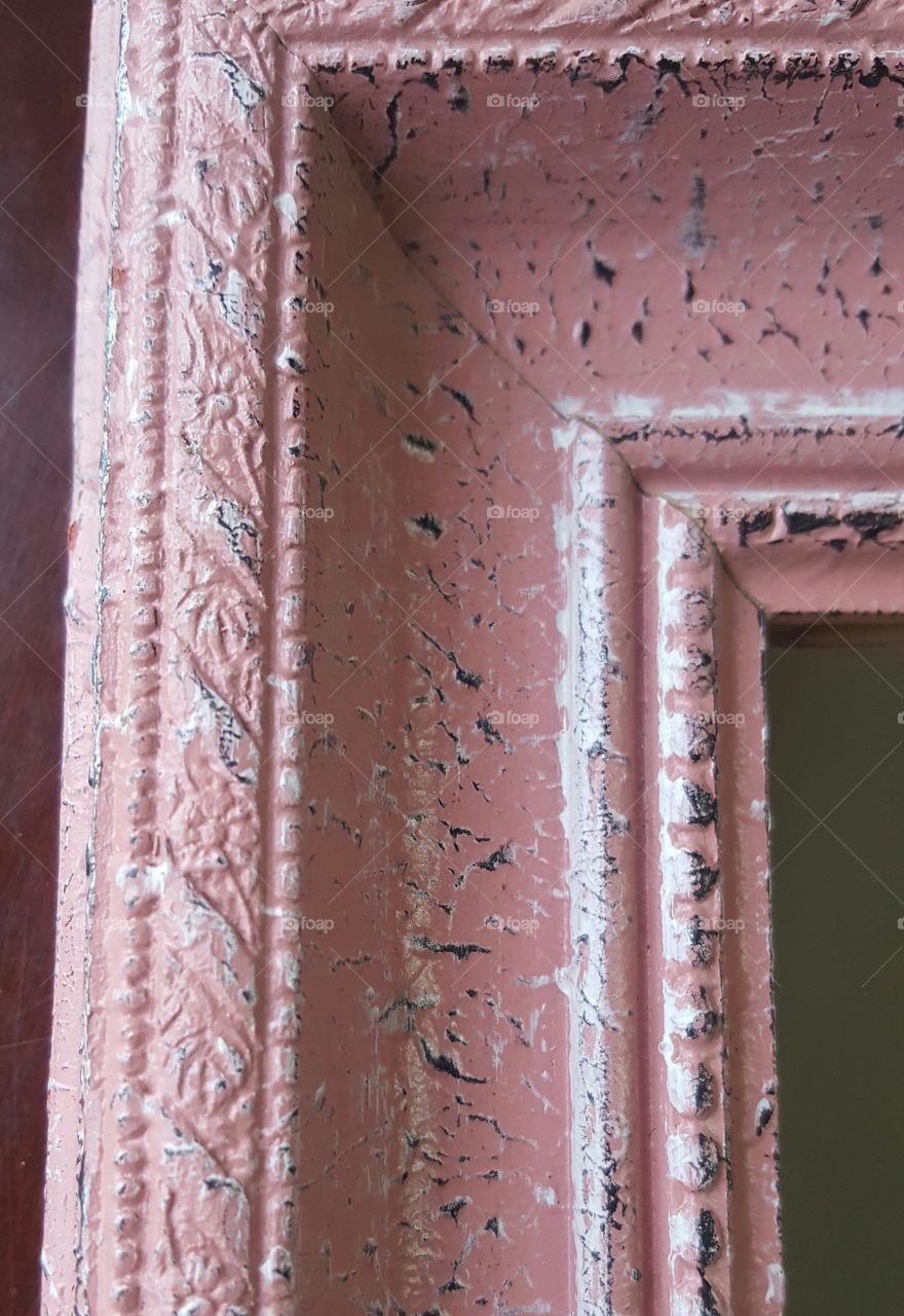 Close-up view of a light pink antique looking picture frame