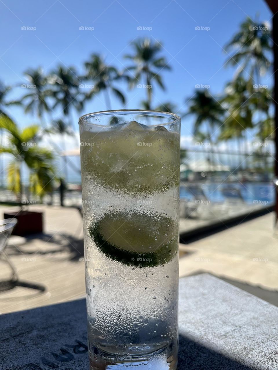 Close-up of a glass of a cold drink with ice cubes and a slice of lemon