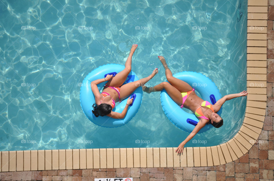Two young ladies enjoying a relaxing day in the pool.
