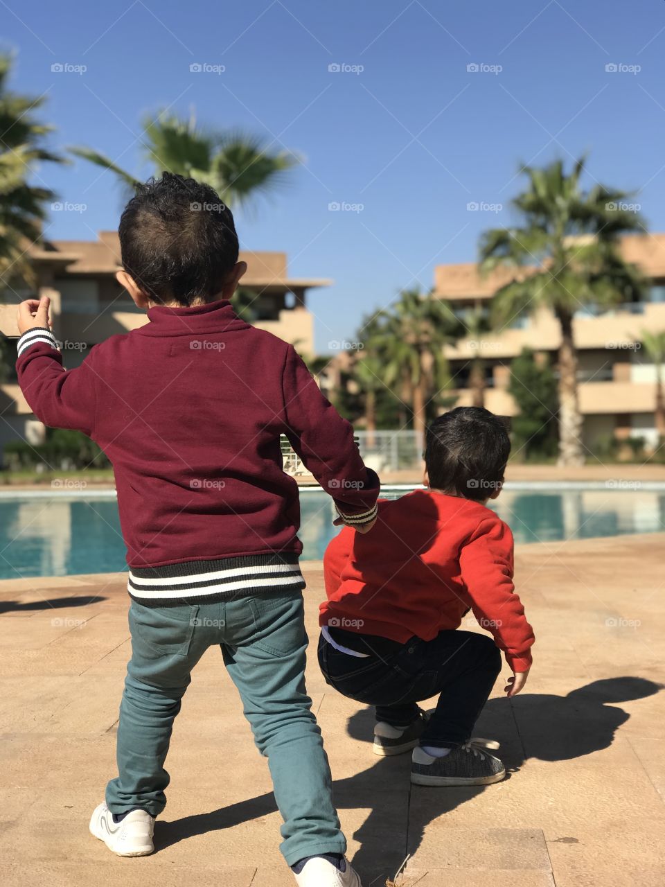 Kids playing front of the swimming pool 