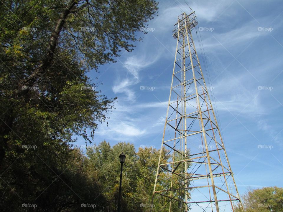 Perspective tall electrical tower wispy clouds 